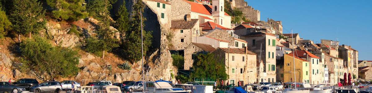 Dramalj, village in Crikvenica, Croatia. Summer holiday destination, view from across the sea. Shore And Boats On Adriatic Coastline with reflection.