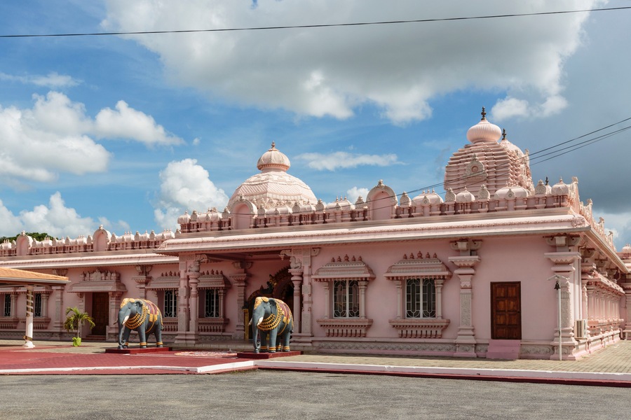 Un temple rose avec deux éléphants devant.