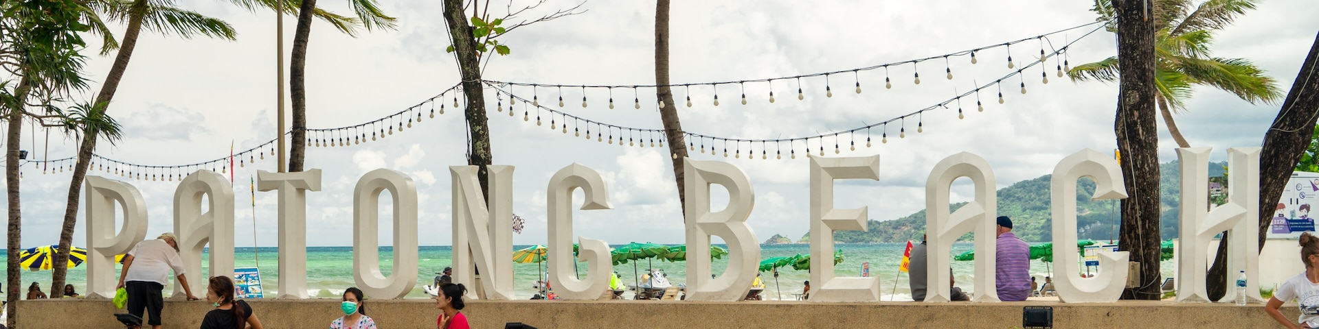 A beach with palm trees and a sign reading 'POTONG BEACH'.