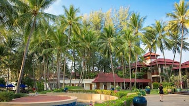 Een resort met palmbomen, een zwembad en een gebouw met een rood dak.