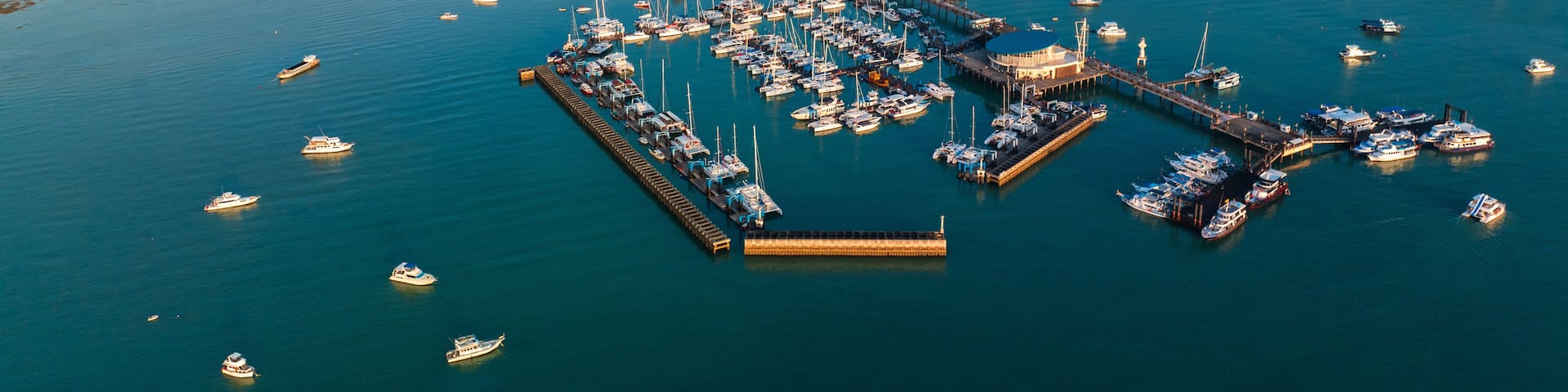 Aerial drone view of Chalong pier with many boats at sunrise, Phuket, Thailand