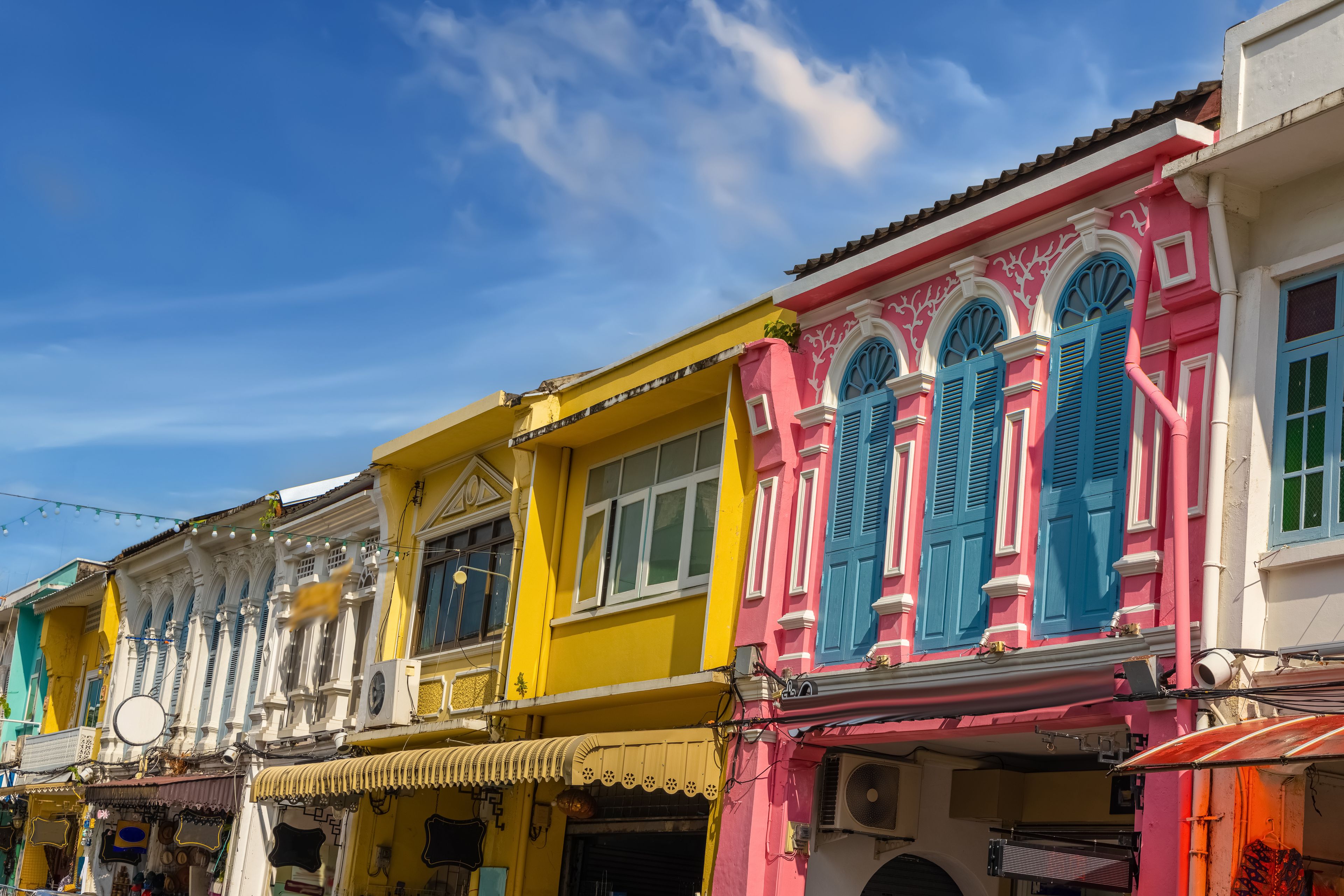 A row of colorful buildings with distinctive architectural features, including arched windows and decorative moldings.