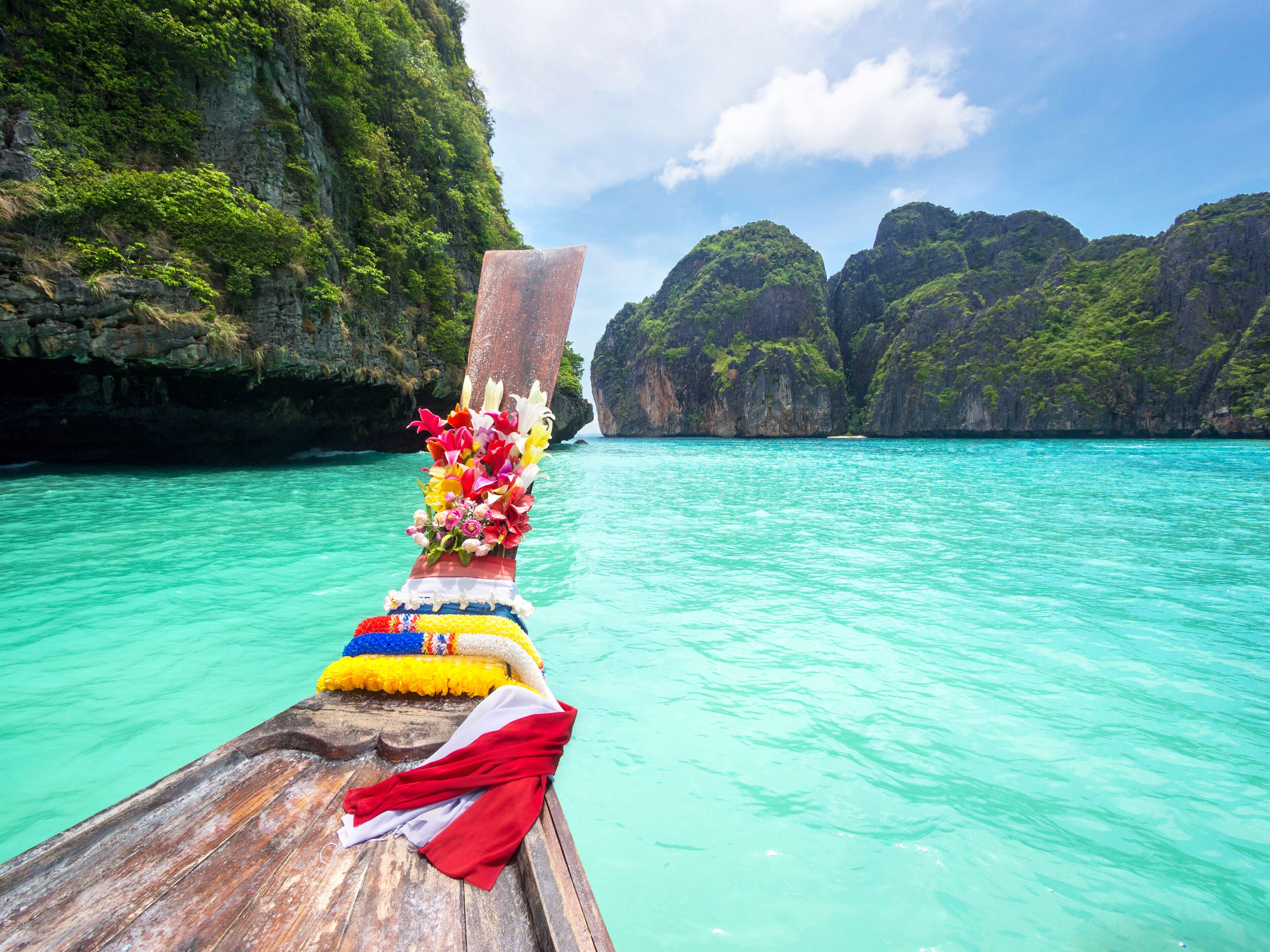 Traditional longtail boat in the turquoise colored waters of Maya Bay, Ko Phi Phi, Thailand.; Shutterstock ID 217078000