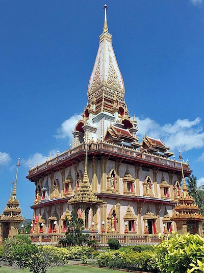 Not far from Phuket Town is the stunning Wat Chalong. We’ve visited a lot of wats in South East Asia, and this one certainly had its own unique flare.
The Grand Pagoda dominates the temple grounds–it’s cool and breezy location makes it just as popular as the splinter of Buddha’s bone that rests inside. The pagoda walls depict Buddha’s life story and immense golden statues of the various Buddha poses sit in the main hall. Choose the one you wish to worship to most.
Pay attention to the fire crackers going off inside the brick oven out the front of the ordination hall. Thai people set them off to celebrate if they receive any good luck.