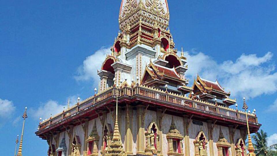 A large, ornate temple with a tall spire and multiple smaller structures.
