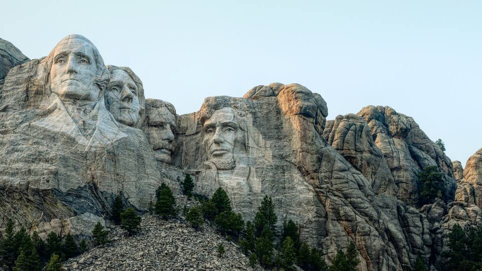 Mount Rushmore with four large stone faces carved into the mountain.