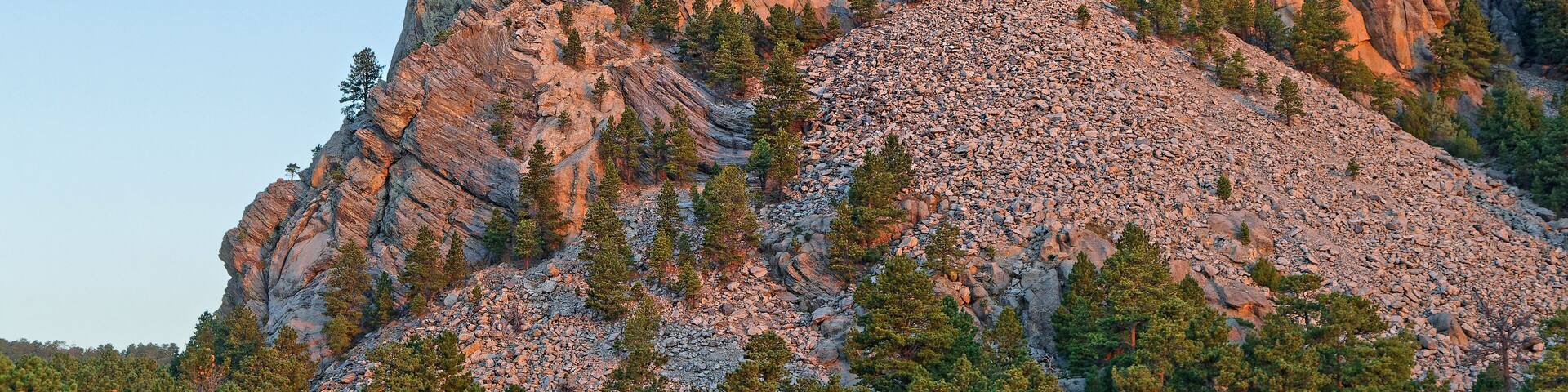 A mountain with a large rock face featuring a prominent carving of a face.