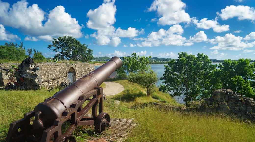 Old cannon in the fort is looking at sea with amazing clouds and island on background