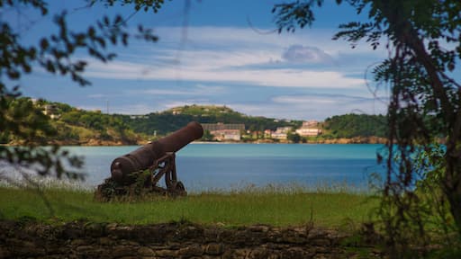 Old cannon in the fort is looking at sea with amazing clouds and island on background