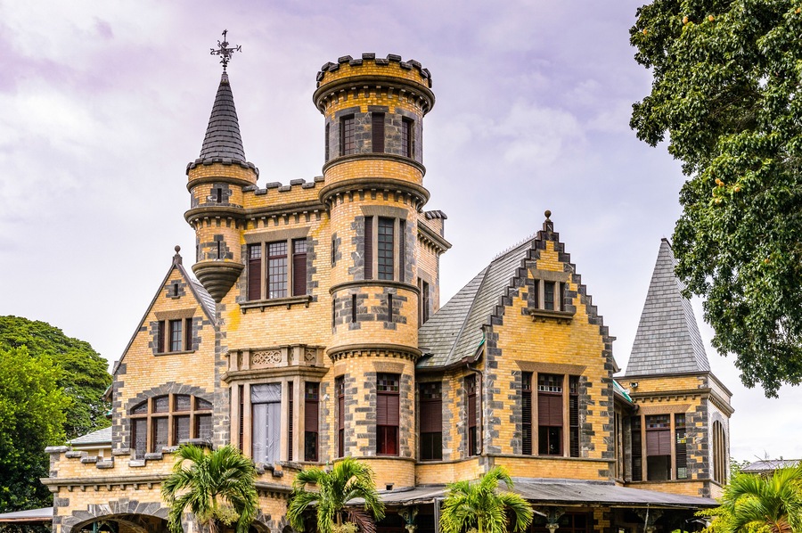 A large, ornate building with multiple towers and turrets, featuring intricate stonework and a mix of brick and stone materials.