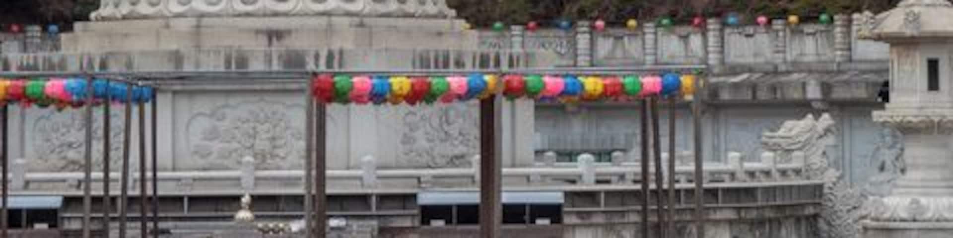 Reunification Buddha at Doughwasa Temple
Donghwasa Temple is on the southern side of Mt. Palgongsan, South Korea.
On its grounds is a 17 meter high statue of a Buddha of Medicine (Yaksayore-bil). Medical Buddhas are often depicted wearing a hat. It was completed in 1992 in hopes of reunification of the Korean Peninsula.
Donghwasa Temple is one of the temples involved in the Temple Stay Program. This is a program which allows lay people to stay a night or two and experience Buddhist practices.