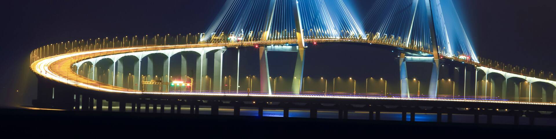 Illuminated Incheon Bridge over sea against sky at night