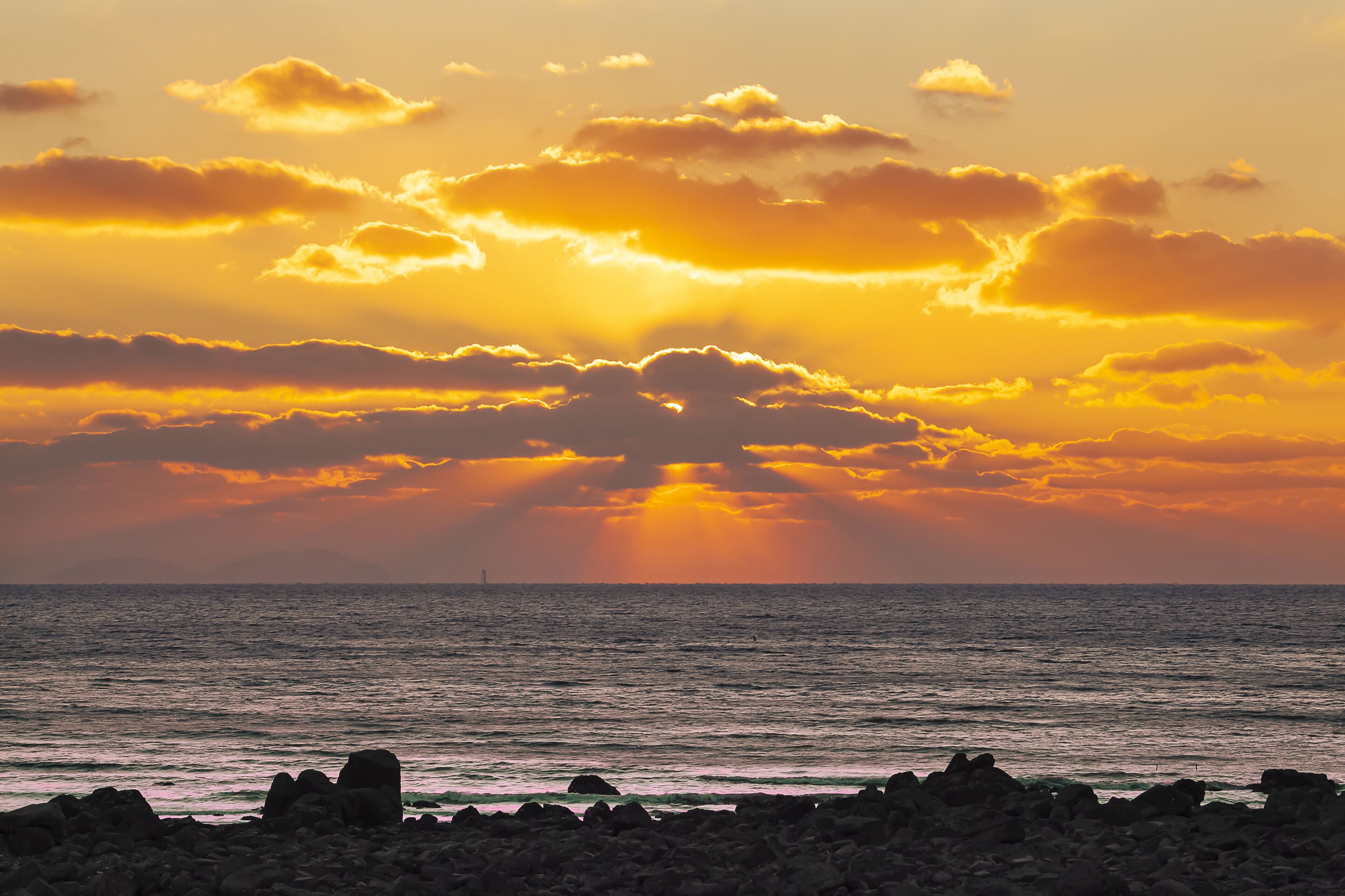 Winter and sunset view of seaside rock against sea horizon at Seonnyeobawi Beach of Eulwang-ri near Yongyu Island of Jung-gu, Incheon, South Korea
