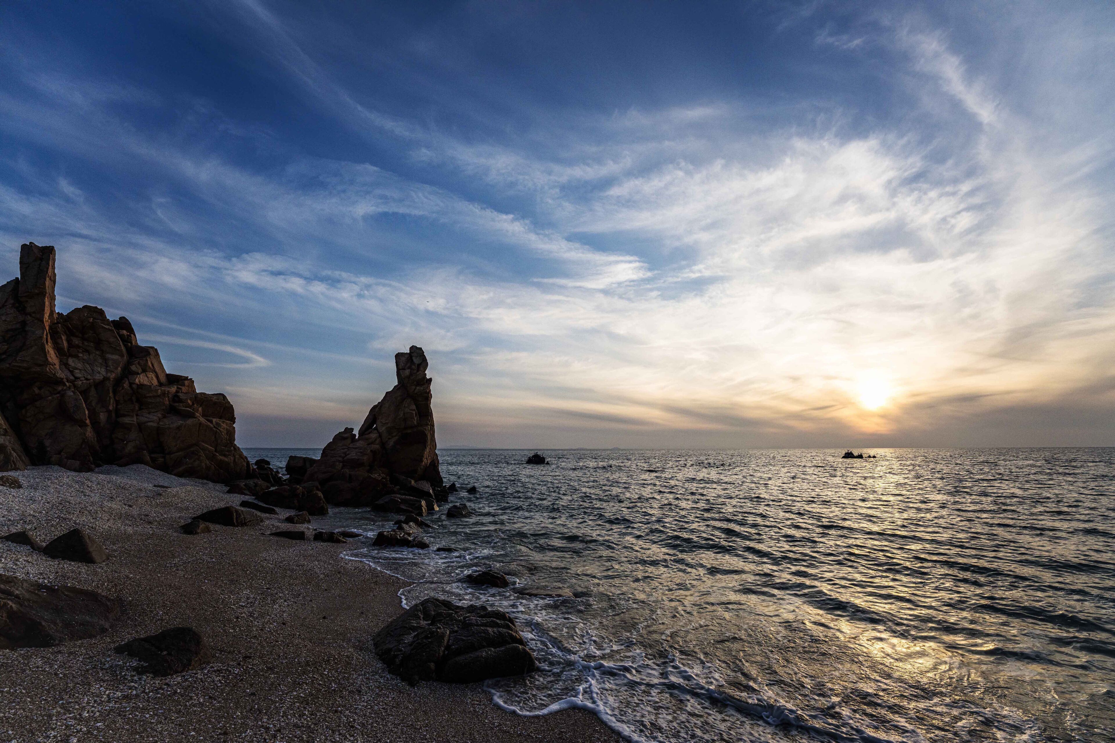 Sunset view of sandy beach and sea wave with Seonnyeobawi Rock at Seonnyeobawi Beach of Eulwang-ri near Jung-gu, Incheon, South Korea
