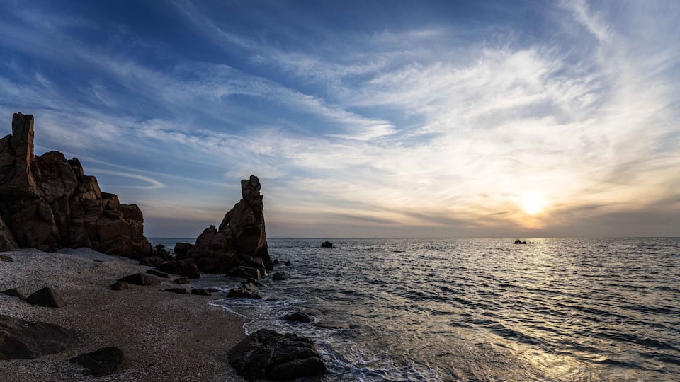 Sunset view of sandy beach and sea wave with Seonnyeobawi Rock at Seonnyeobawi Beach of Eulwang-ri near Jung-gu, Incheon, South Korea