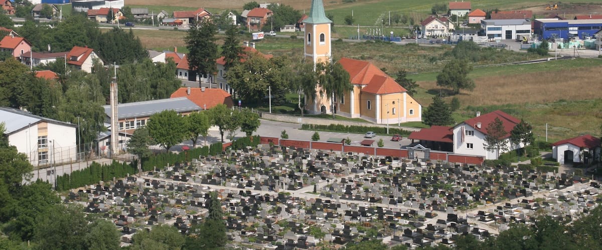 A town with a church, a cemetery, and surrounding residential buildings.