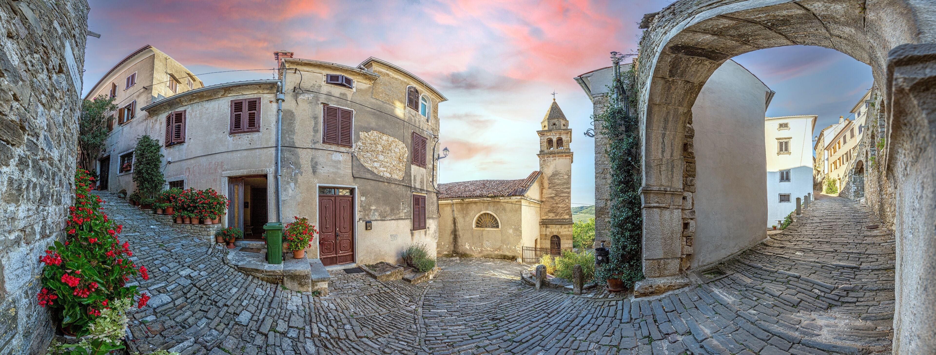 View over the cobblestone historic access road to Motovun with evangelical church during the day