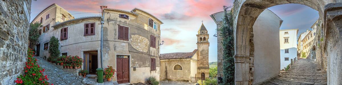 View over the cobblestone historic access road to Motovun with evangelical church during the day