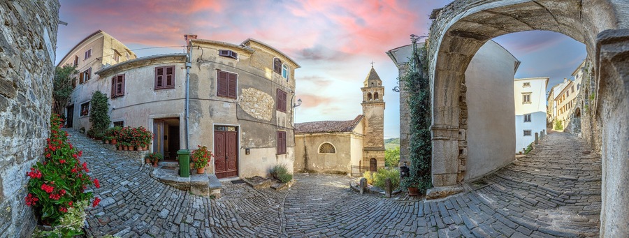 View over the cobblestone historic access road to Motovun with evangelical church during the day