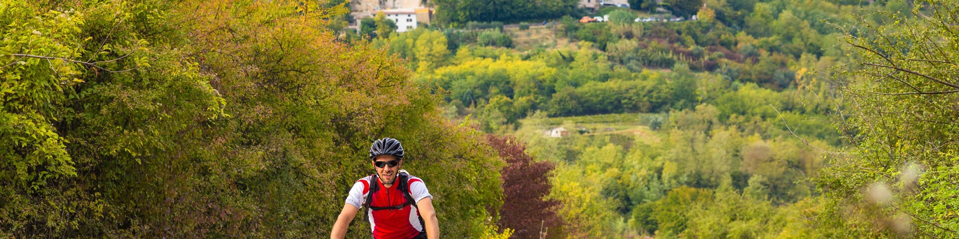 A cyclist on a dirt path with a castle in the background.