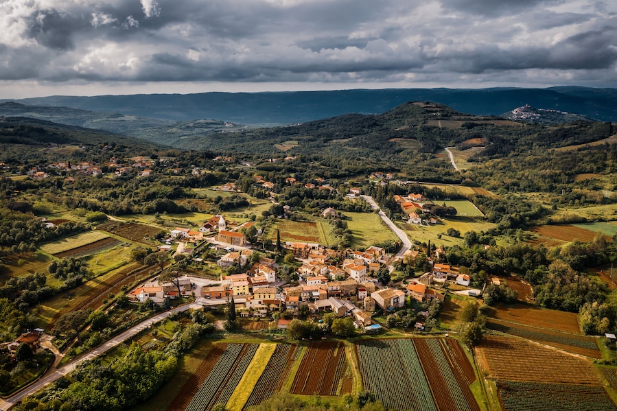 Aerial view of a village with mountains in the background on cloudy day in Karojba, Croatia
