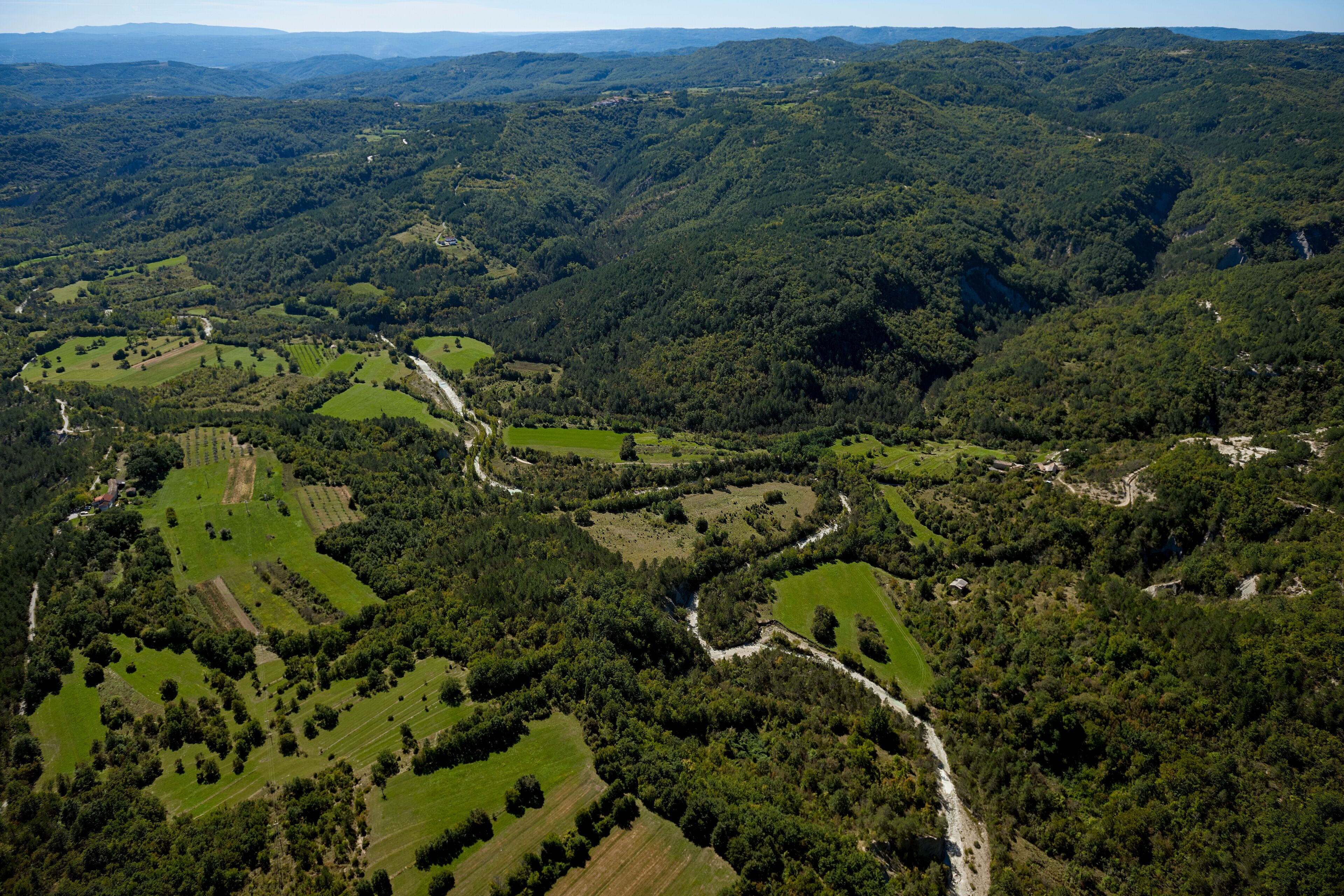 Aerial view of lush greenery, hills, and mountains surrounding River Pazincica, Cerovlje, Istria, Croatia.