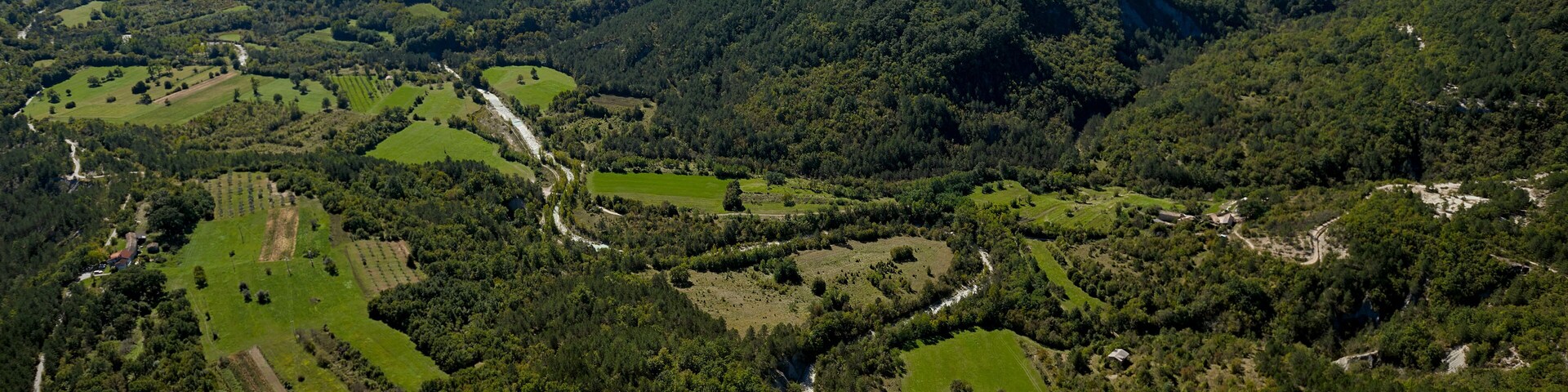 Aerial view of lush greenery, hills, and mountains surrounding River Pazincica, Cerovlje, Istria, Croatia.
