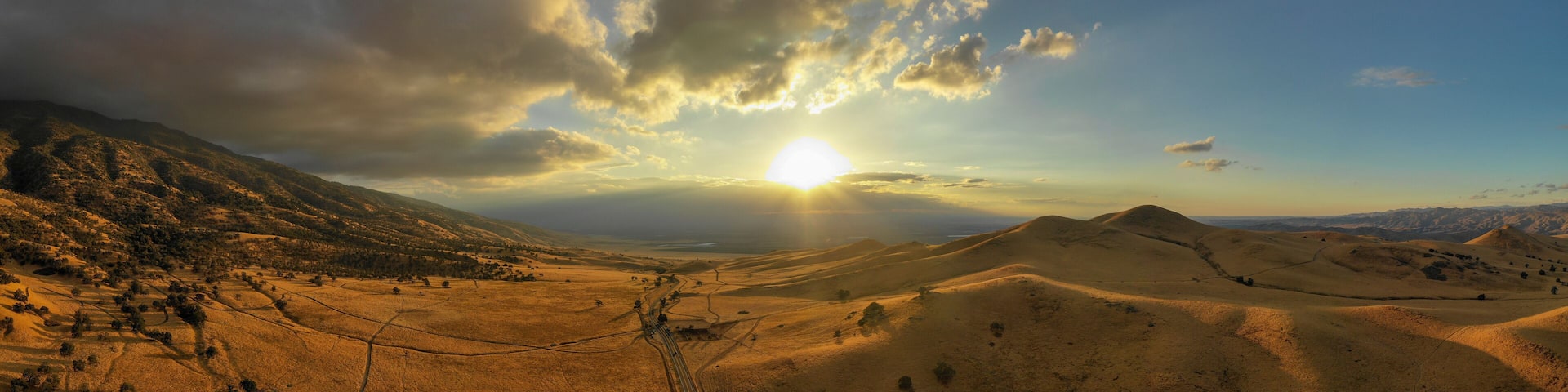 A mountainous landscape with a valley and a railway track.