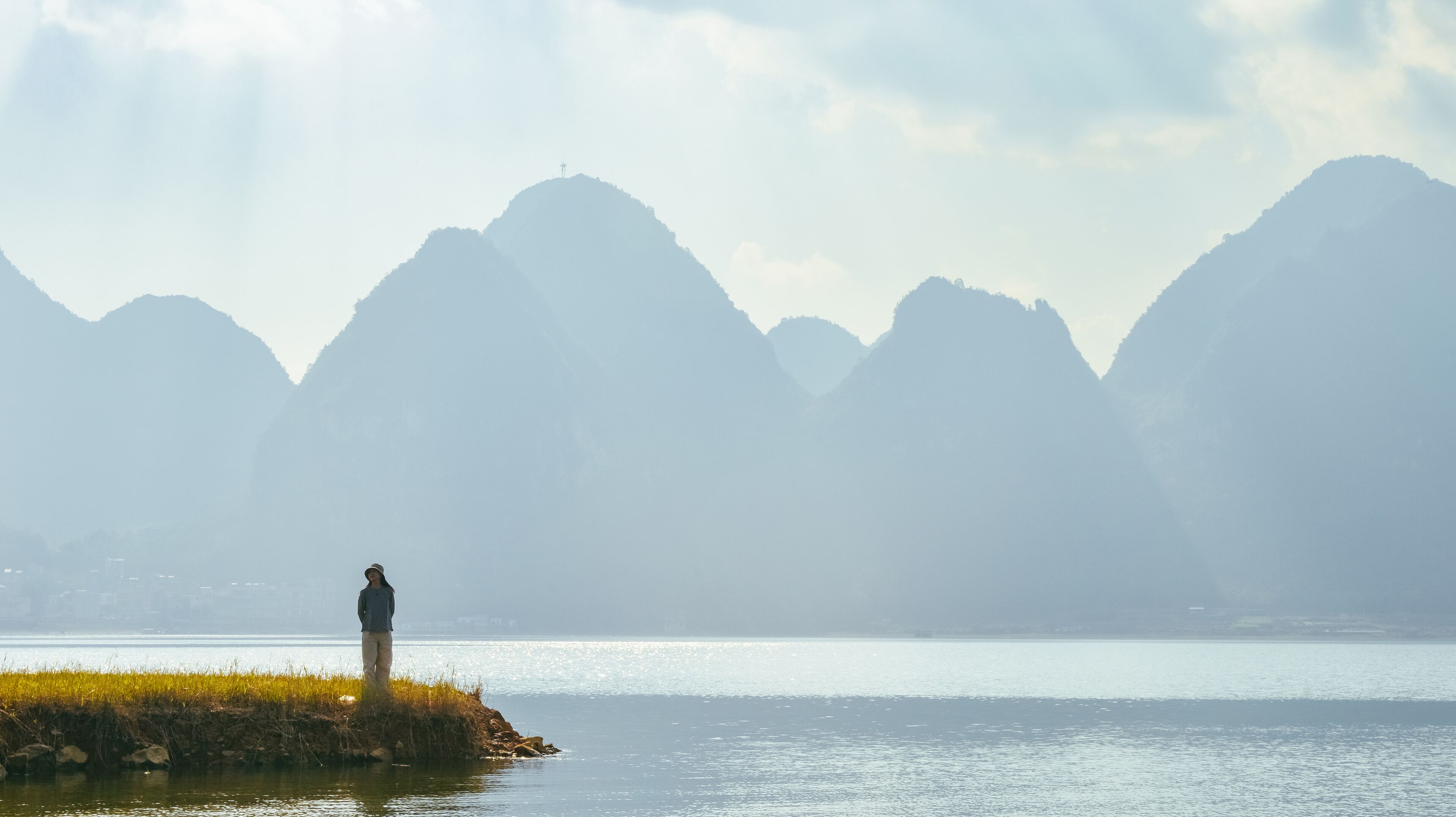 One Asian woman enjoying beautiful  karst peaks landscape at Quyang Lake (Quyanghu), Baise city, Guangxi province, China