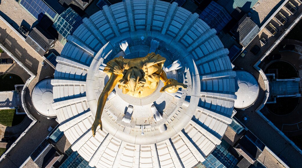 A circular plaza with a central sculpture surrounded by benches.