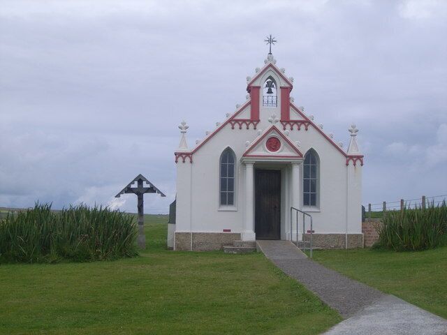 A small white church with a red roof and a bell tower.