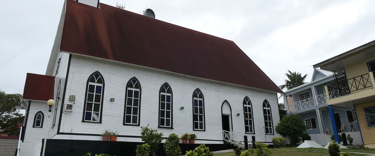 A white church with a red roof and a bell tower.
