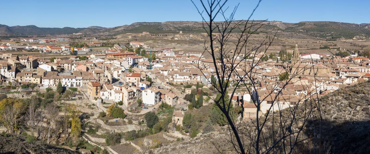A town nestled in a valley with terraced fields, historic buildings, and a prominent church tower.