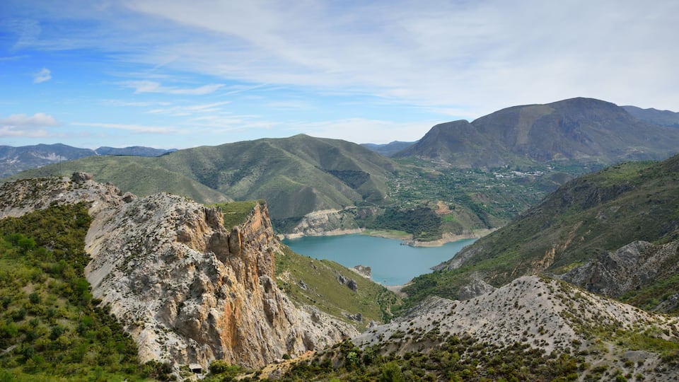 A mountainous landscape with a lake and distant hills.