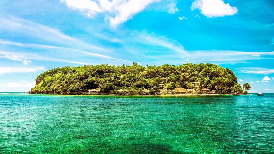 A lush, green island surrounded by turquoise waters.