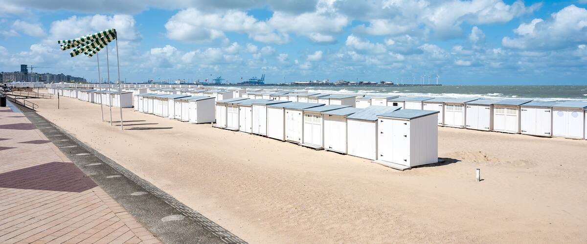 A beach with portable cabins and a checkered flag.