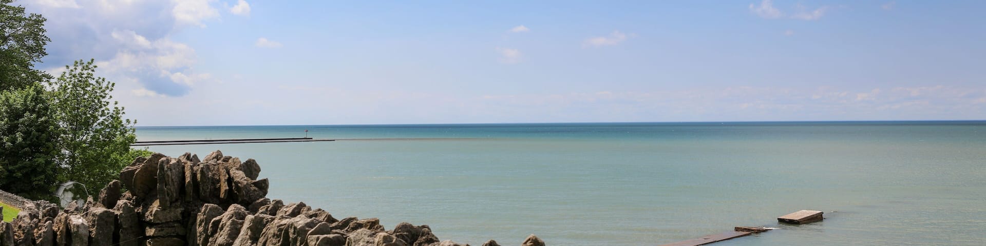 View of Lake Ontario at Olcott Beach. Stone wall at Krull park overlooking the pier.