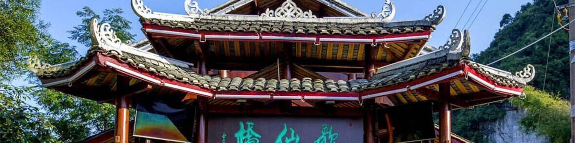 A traditional Chinese pavilion with ornate architecture and a signboard.