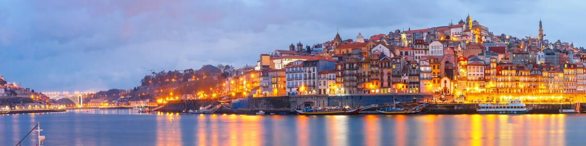 Ribeira and Old town of Porto with mirror reflections in the Douro River during evening blue hour, Portugal, Portugal.
