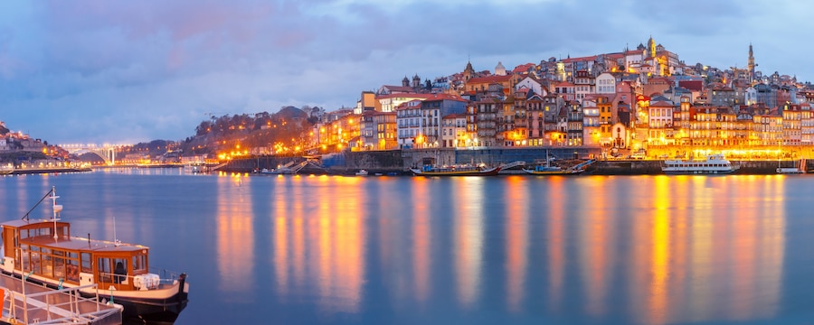 Ribeira and Old town of Porto with mirror reflections in the Douro River during evening blue hour, Portugal, Portugal.