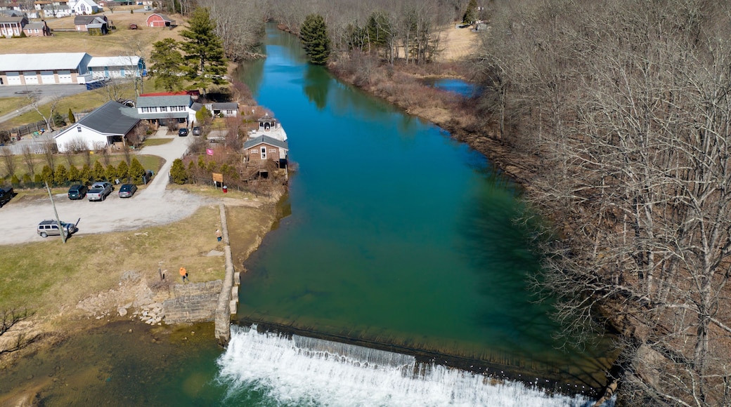 A river flowing through a town with a dam, houses, and a church.