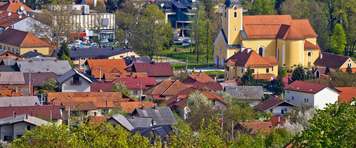 A town with red-roofed houses, a church, and a mix of modern and traditional buildings.