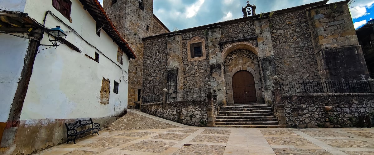 A historic stone building with a bell tower and a large wooden door.