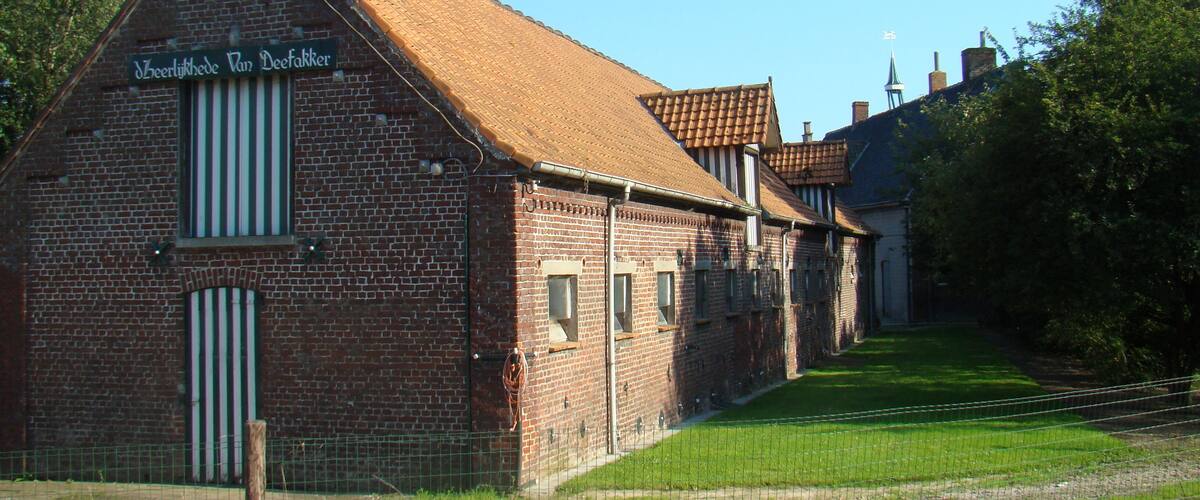 A brick building with a sign reading "Jeverliede Van Deefakker".