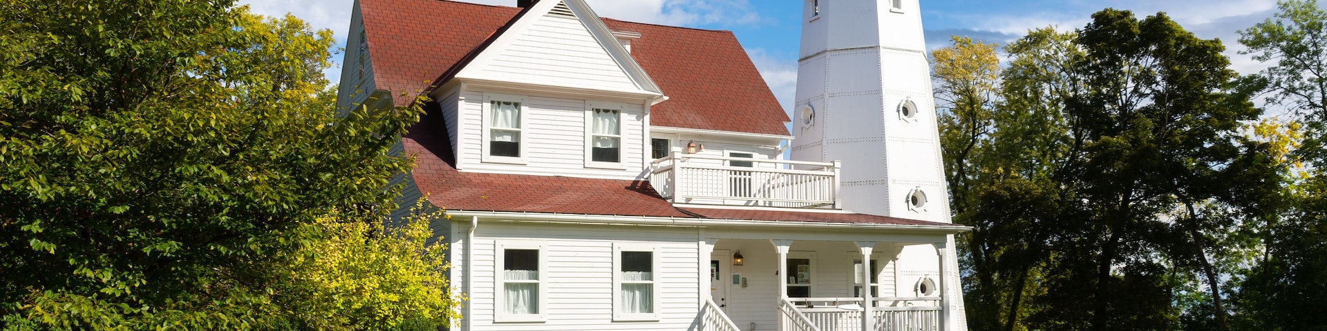 Ein weißes Haus mit rotem Dach und einem weißen Leuchtturm.