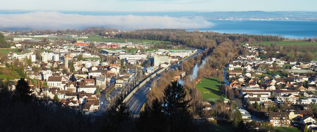 A town with a river, industrial buildings, and a bridge.