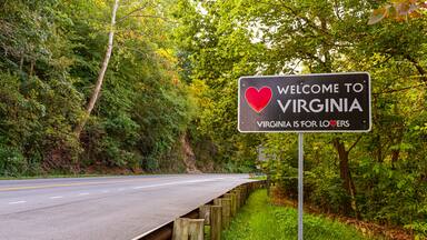 Welcome to Virginia sign located at the Maryland, Virginia state border at Purcellville, Virginia. The black sign has a red heart shape and 'Virginia is for lovers' slogan underneath.