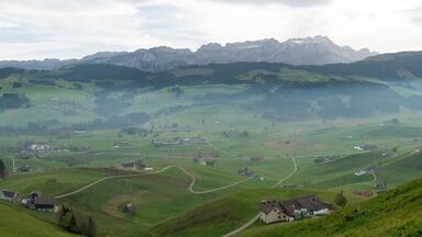 panorama landscape view of the beautiful Appenzell region in Switzerland with ist rolling hills and farms and the Alpstein mountains behind