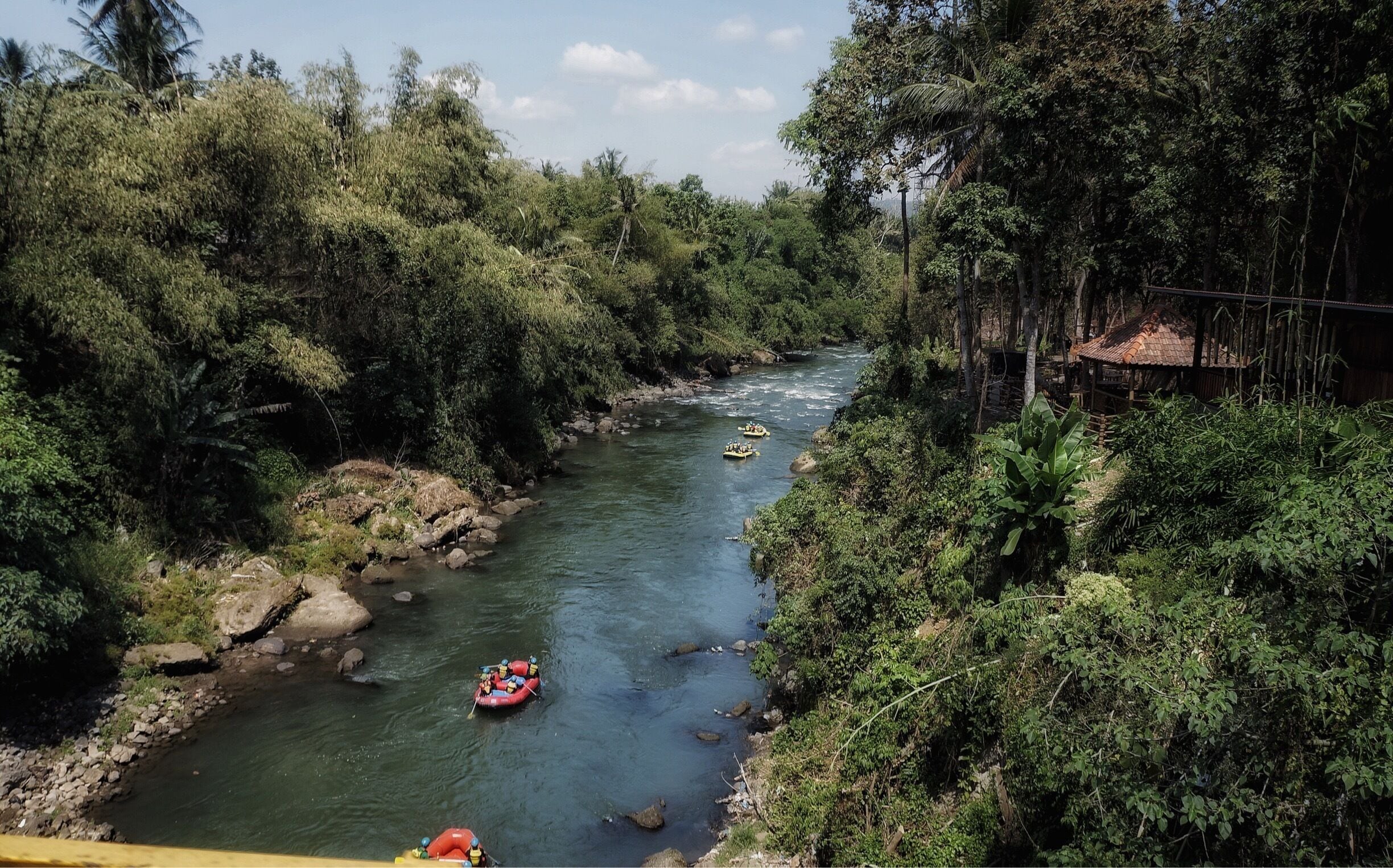 Un río con dos barcas amarillas y una roja.