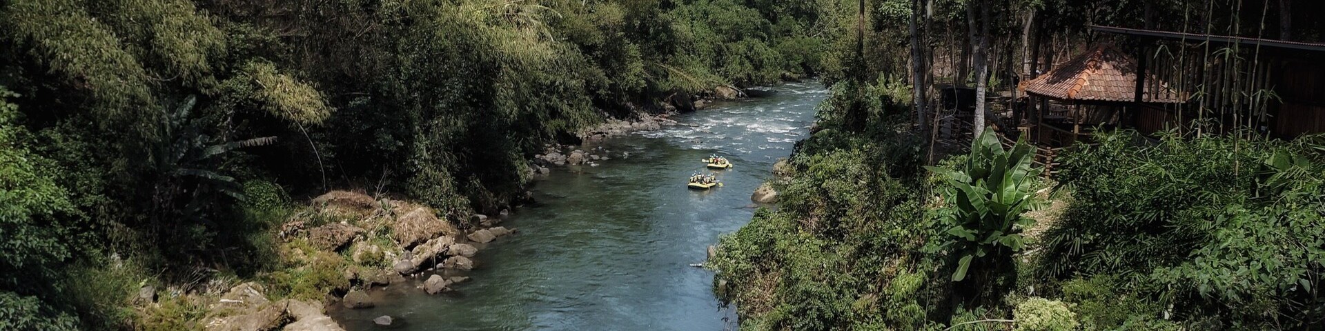 Un río con dos barcas amarillas y una roja.
